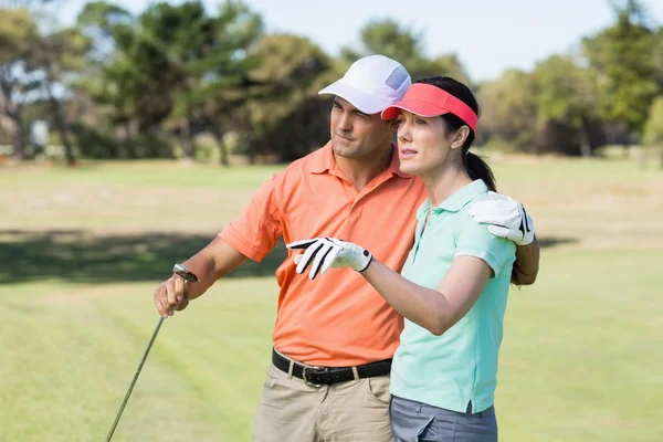 Golfista mulher apontando enquanto está de pé pelo homem — Fotografia de Stock