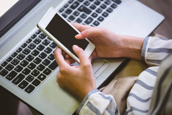 Executivo usando celular sobre laptop — Fotografia de Stock