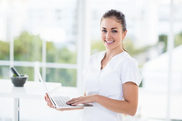 Uśmiechnięta kobieta korzystająca z laptopa — Zdjęcie stockowe