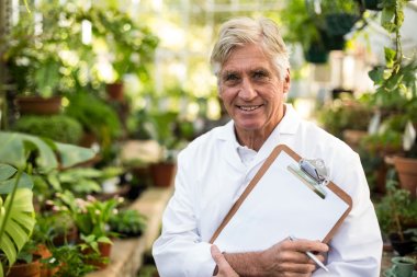 scientist holding clipboard at greenhouse clipart