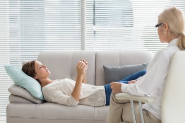 Woman talking to therapist while lying on sofa clipart