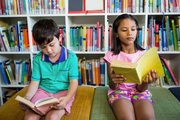 Étudiants lisant des livres à la bibliothèque scolaire — Photo