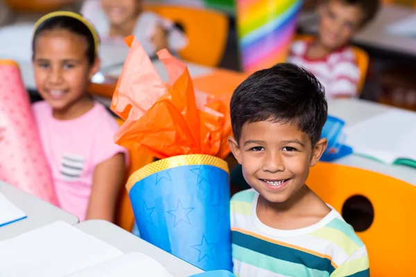 Chico con compañeros de clase sosteniendo artículo de artesanía — Foto de Stock