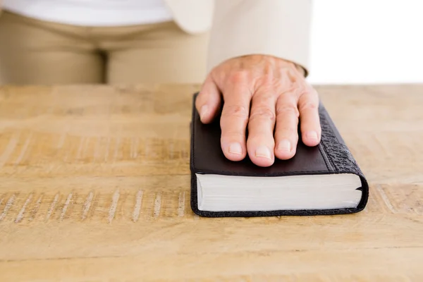 Frau mit Hand auf Bibel — Stockfoto