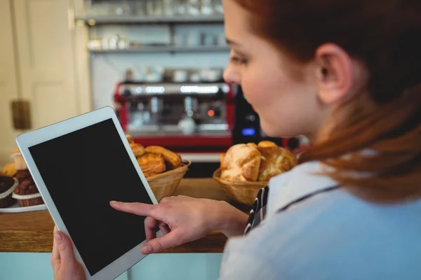 Barista desplazándose tableta en la cafetería — Foto de Stock