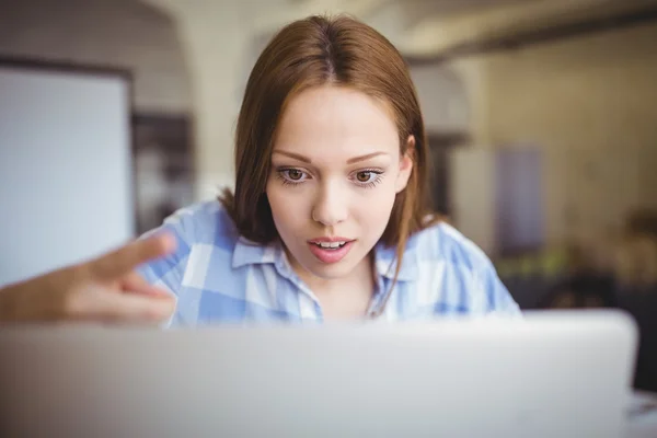 Verbaasd zakenvrouw die op laptop werkt — Stockfoto