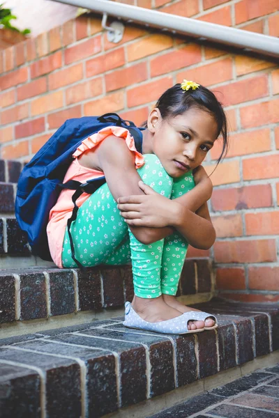 Menina sentada em degraus no corredor — Fotografia de Stock