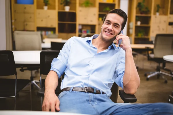 Улыбающийся бизнесмен разговаривает по телефону — стоковое фото