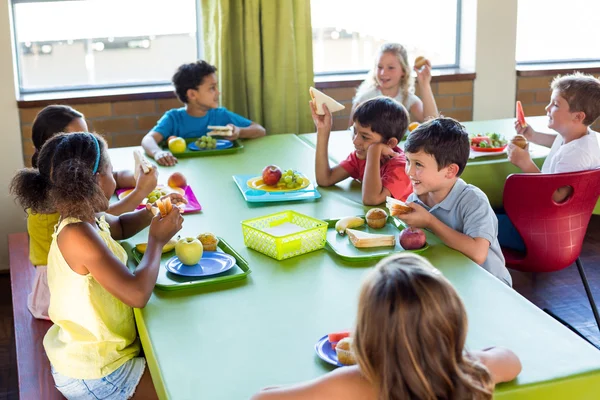 Crianças em idade escolar tendo refeição — Fotografia de Stock