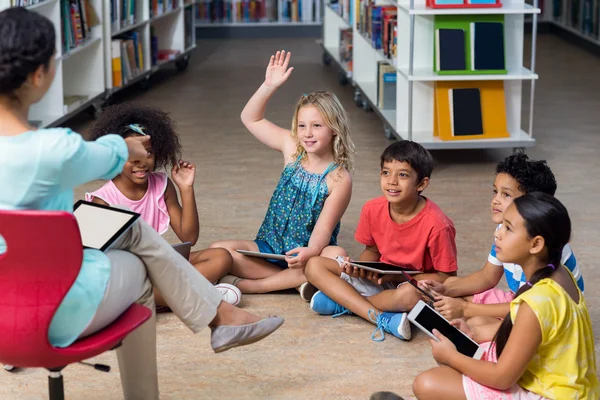 Teacher pointing at arm raised student — Stock Photo, Image