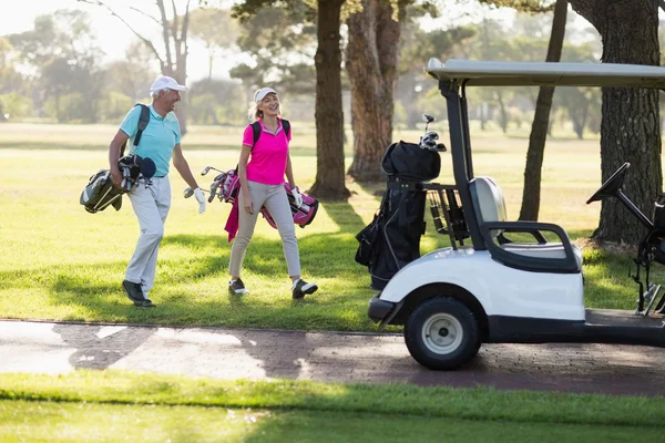 Mogna golfspelare par av golf buggy — Stockfoto