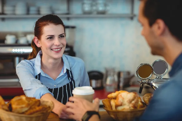 Barista offering coffee to customer at cafe — Stock Photo, Image
