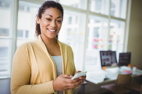 Zakenvrouw met behulp van de telefoon bij creatieve Bureau — Stockfoto