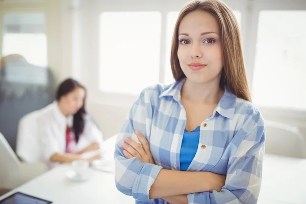 Businesswoman with colleague in background — Stock Photo, Image