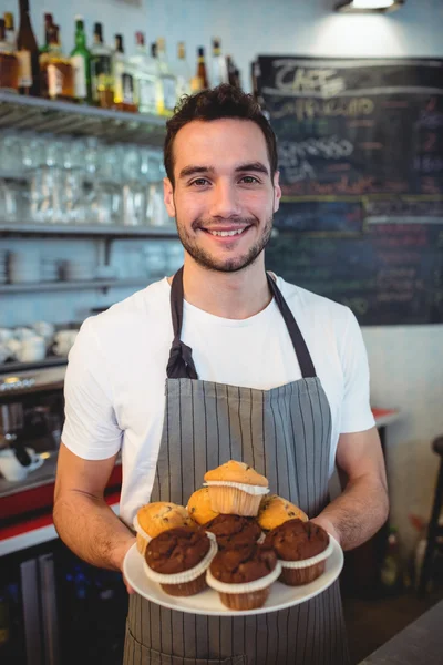 Camarero seguro con cupcakes en la cafetería — Foto de Stock