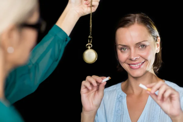 Hypnotherapist holding pendulum by patient — Stock Photo, Image