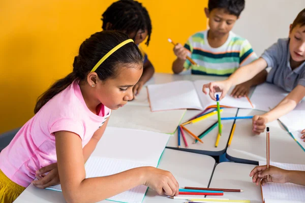 Niños con libros y lápices en la mesa —  Fotos de Stock