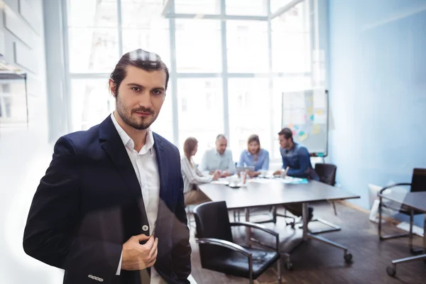 Säker affärsman står mot medarbetare — Stockfoto