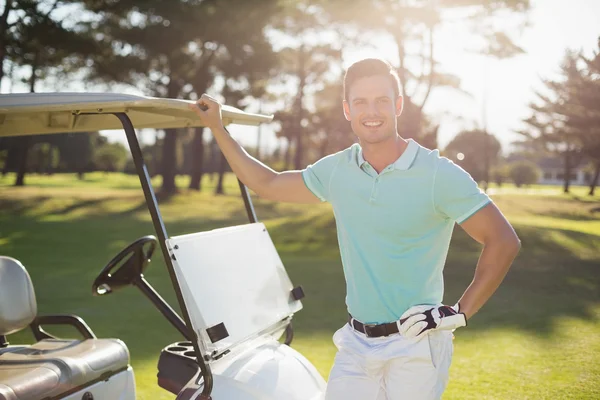 Jovem sorridente por buggy de golfe — Fotografia de Stock