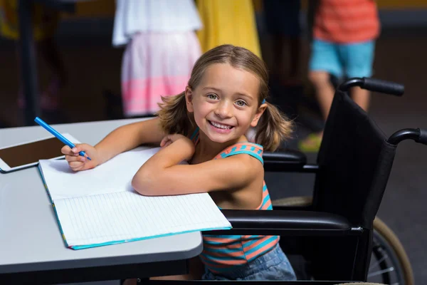 Niña en silla de ruedas en el aula — Foto de Stock