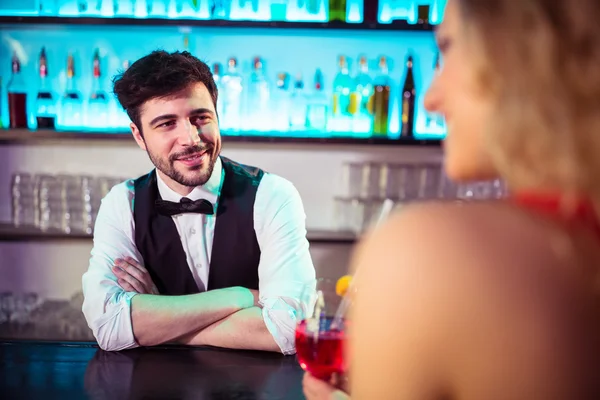 Bartender looking at woman in nightclub — Stock Photo, Image