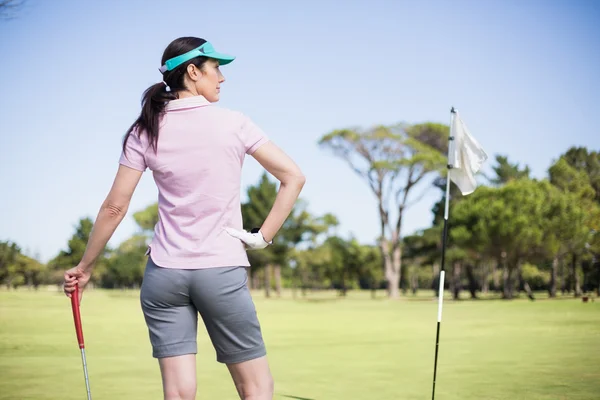 Frau hält Golfschläger mit Hand an Hüfte — Stockfoto