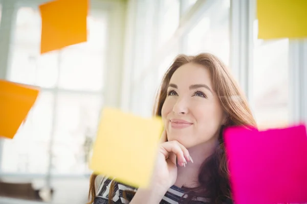 Businesswoman looking at adhesive notes — Stock Photo, Image