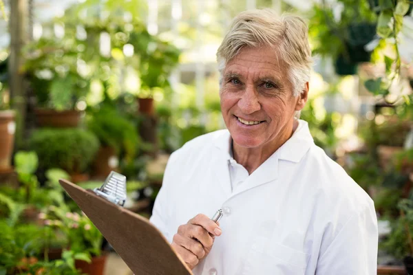 Científico masculino senior sujetando portapapeles — Foto de Stock