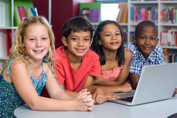 Glückliche Klassenkameraden mit Laptop — Stockfoto