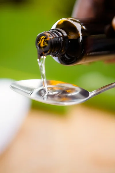 Person pouring medicine in spoon — Stock Photo, Image