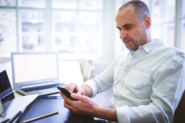 Businessman using phone at desk — Stock Photo, Image