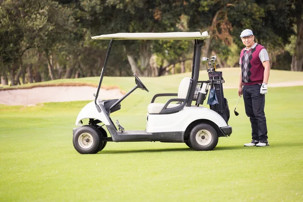 Golfeur posant à côté de son buggy de golf — Photo