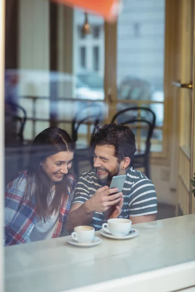 Glada par via mobil på café — Stockfoto