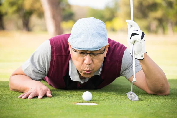 Golfer blowing ball in the hole — Stock Photo, Image