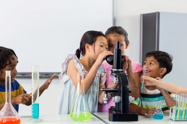 Crianças olhando em microscópio — Fotografia de Stock