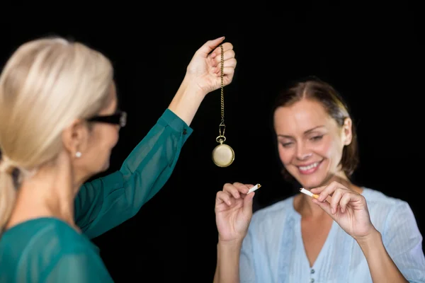 Hipnoterapeuta sosteniendo péndulo por paciente — Foto de Stock