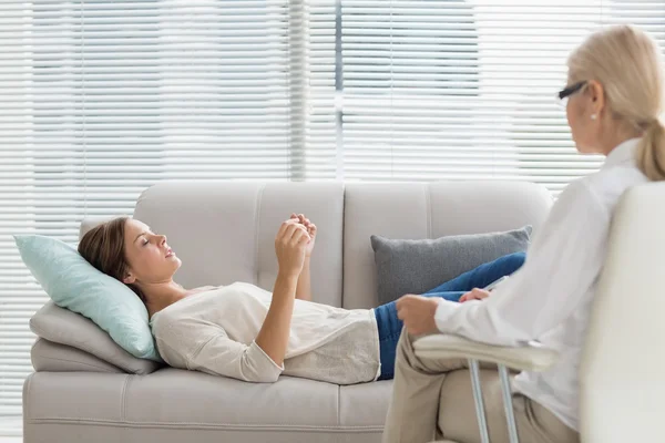 Woman talking to therapist while lying on sofa — Stock Photo, Image