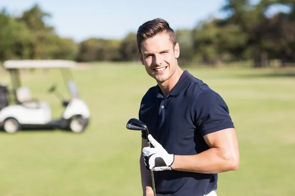 Genç adam holding golf club — Stok fotoğraf