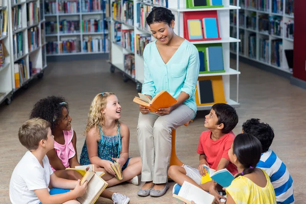 Professor com alunos lendo livros — Fotografia de Stock