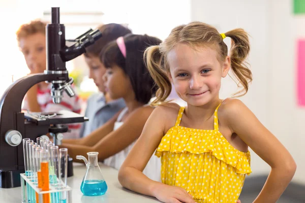 Flicka med klasskamrater i laboratorium — Stockfoto