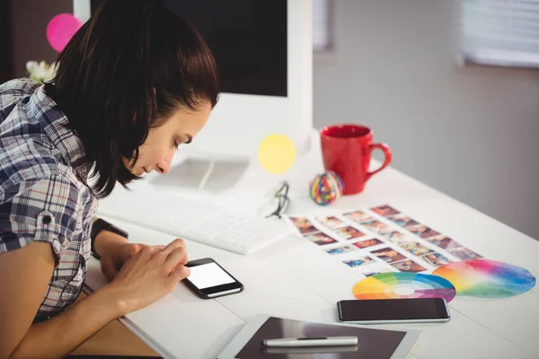 Žena, používání telefonu v kreativní ffice — Stock fotografie