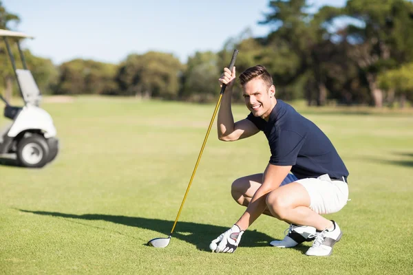 Hombre colocando pelota de golf en la camiseta —  Fotos de Stock
