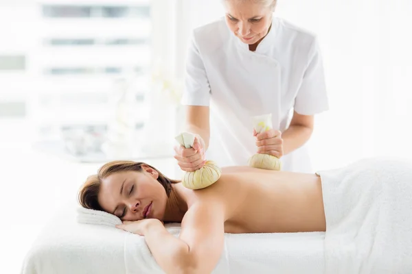 Masseur donnant massage compresse à base de plantes pour femme — Photo