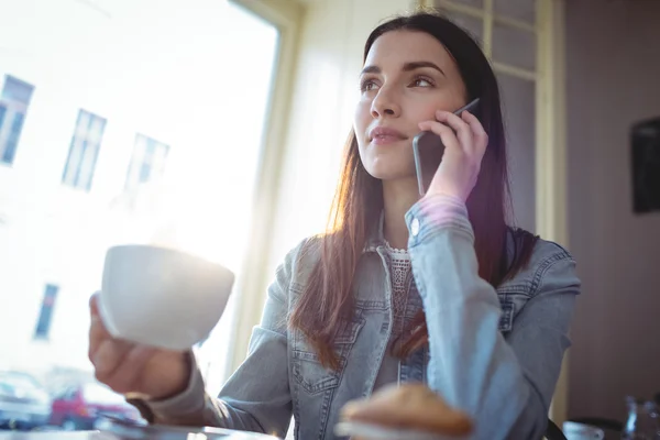 Woman listening to cellphone at coffee shop — Stock Photo, Image