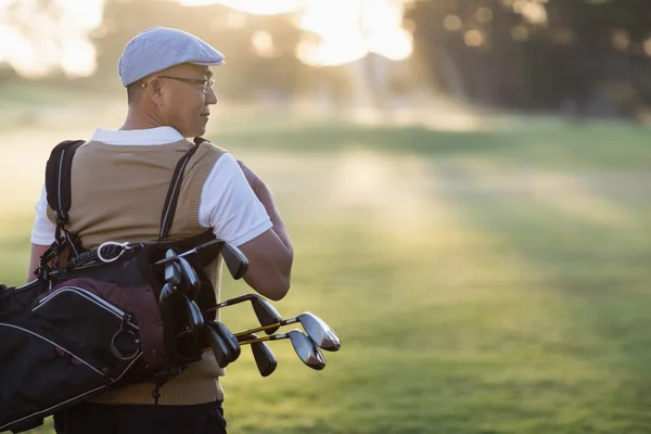 Älterer Mann trägt Golftasche — Stockfoto