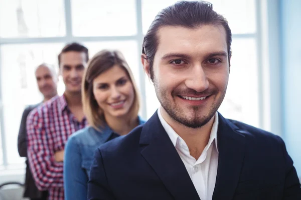 Geschäftsmann mit Kollegen, die in Reihe stehen — Stockfoto