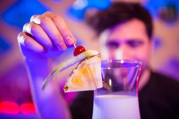 Bartender keeping fruits on cocktail glass — Stock Photo, Image
