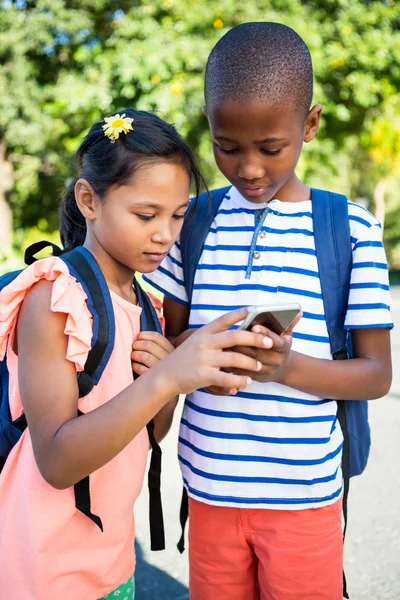 Colegial y niña usando el teléfono —  Fotos de Stock