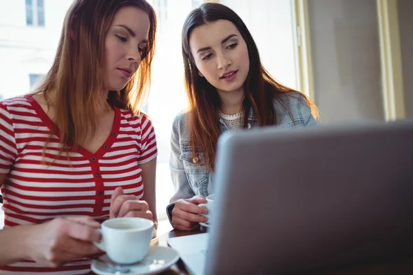 Jóvenes amigos usando el ordenador portátil en la cafetería — Foto de Stock