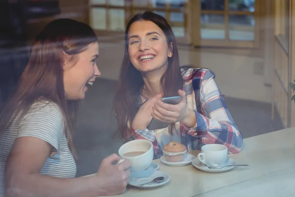 Kvinnor med mobiltelefon på kafé — Stockfoto